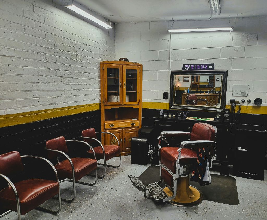 Retro frizerski salon sa crveno-braon kožnim stolicama i starinskim nameštajem